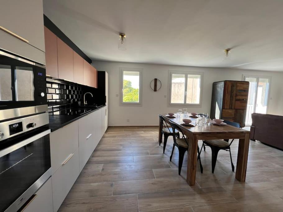 a kitchen and dining room with a table and appliances at Le Saint-Jalmes P2 + Parking in Nîmes
