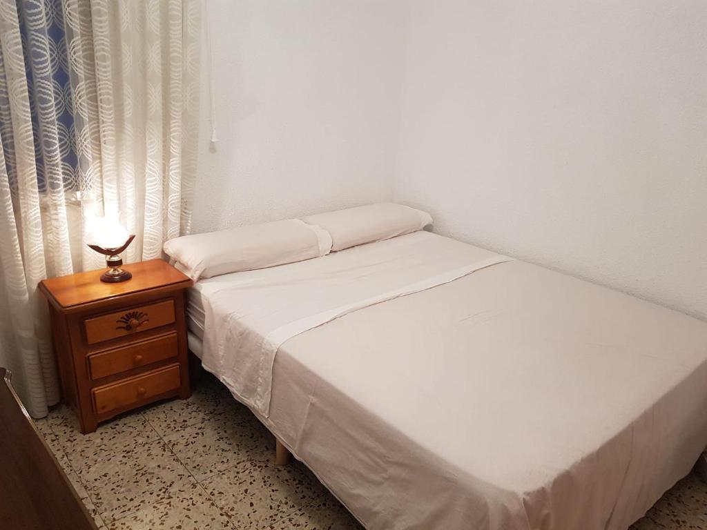 Private Room with Queen Bed في سلامنكا: غرفة نوم بسريرين وطاولة بها مصباح