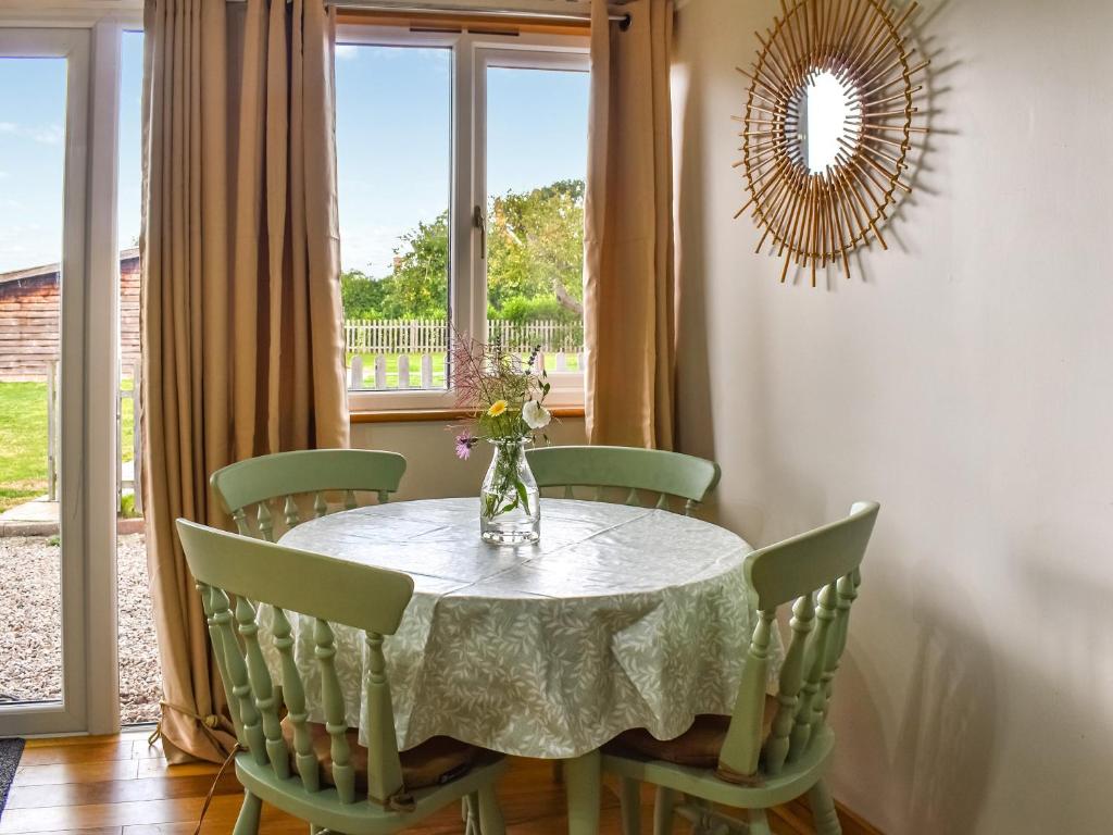 uma sala de jantar com uma mesa e cadeiras e uma janela em Newlyn Cottage em Pluckley