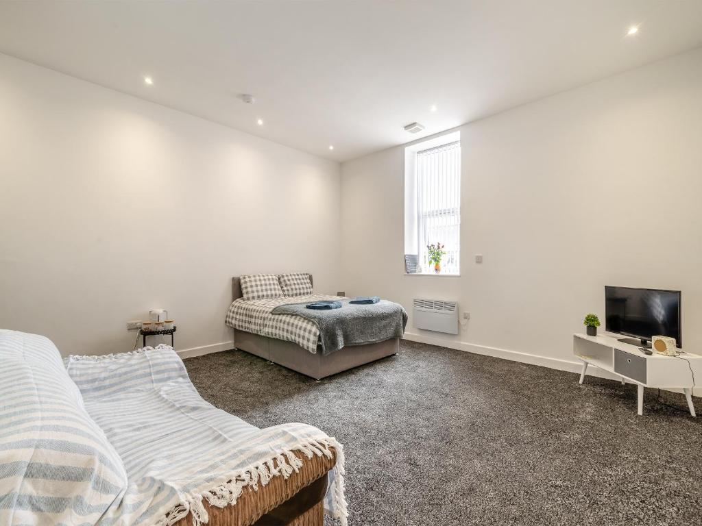 a bedroom with a bed and a couch and a tv at Number Three - Uk44900 in Brierfield