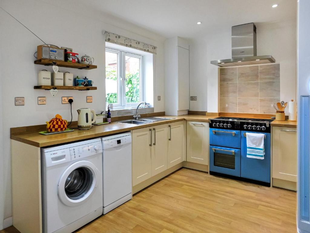 cocina con lavadora y fregadero en Skimming Stones en Sheringham