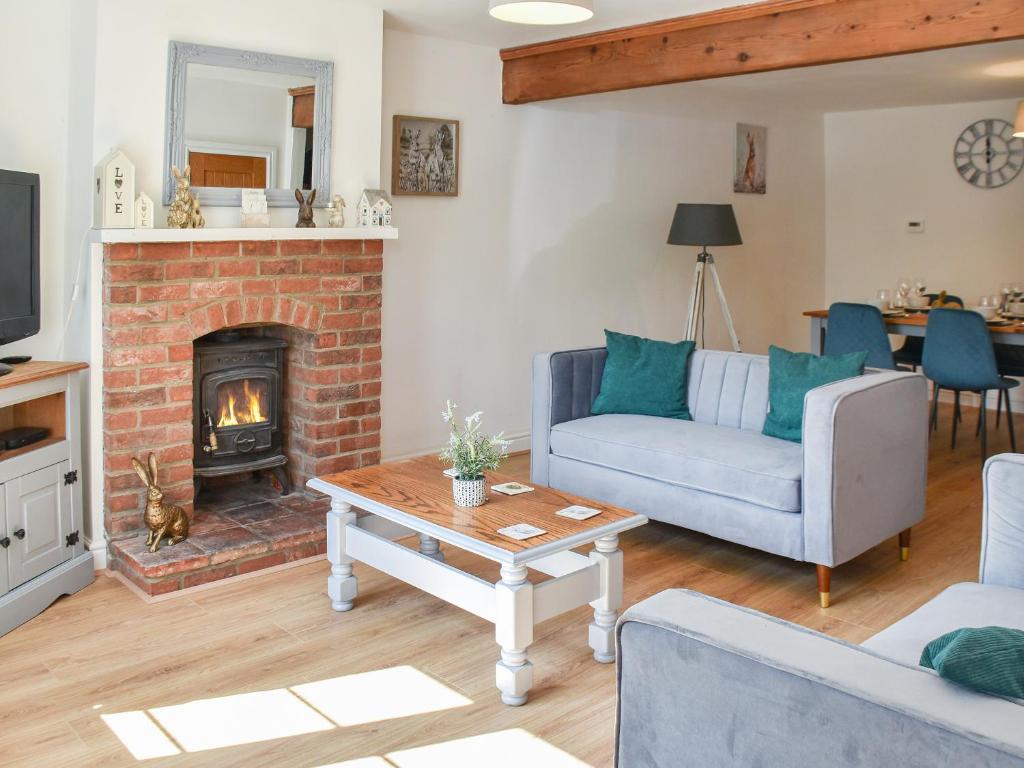 a living room with a couch and a fireplace at Salty Kisses in Mundesley