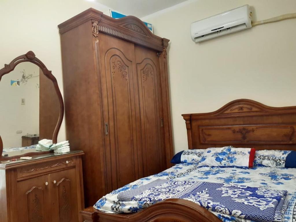 a bedroom with a wooden bed and a dresser at Paradise villa in Dawwār Ḩalīs