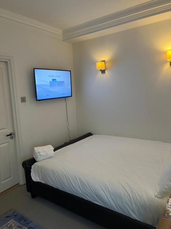 a bedroom with a bed and a flat screen tv on the wall at Luxurious 2 bedroom apartment in Central London in London