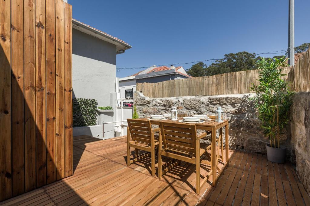 un tavolo e sedie in legno su una terrazza di legno di Bento Guest House a Porto