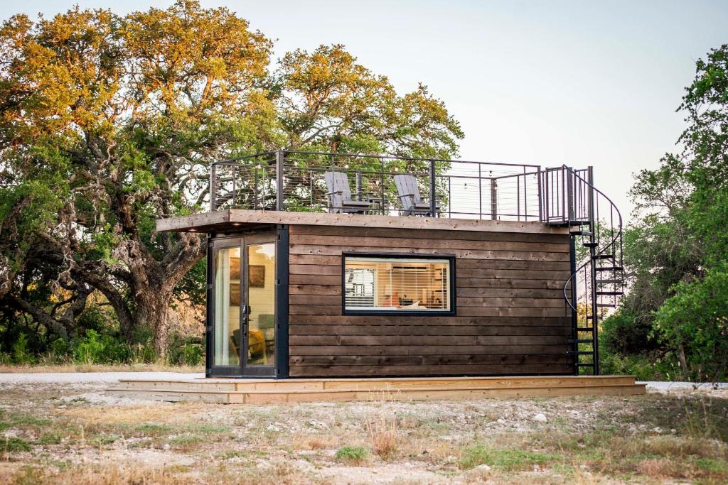 a small house with a balcony on top of it at New The Sunrise Cozy Container Home in Fredericksburg