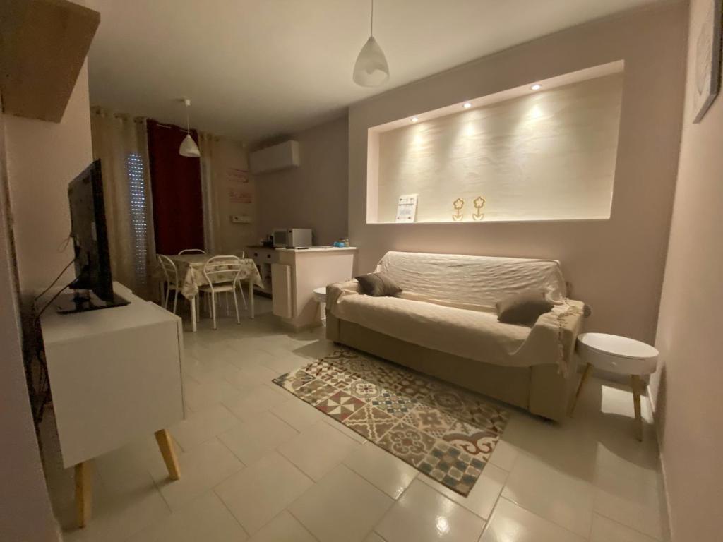 uma sala de estar com um sofá e uma televisão em Casa del Mare em Alghero