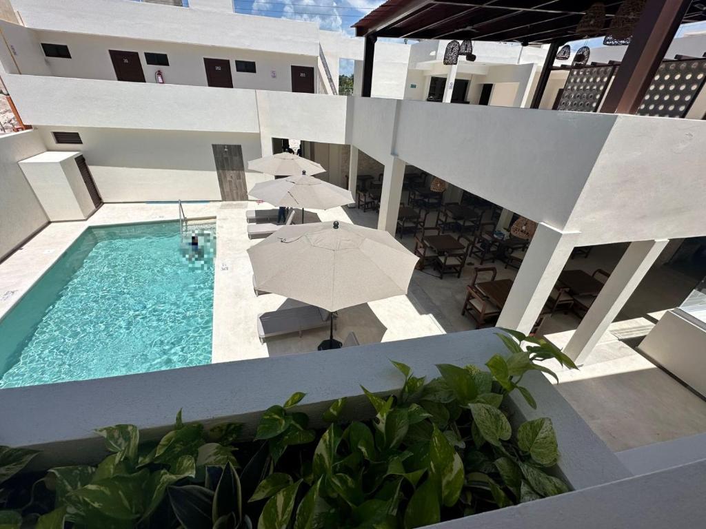 uma vista aérea de um edifício com piscina e guarda-sol em Nuxká Hotel by Heaven em Telchac Puerto