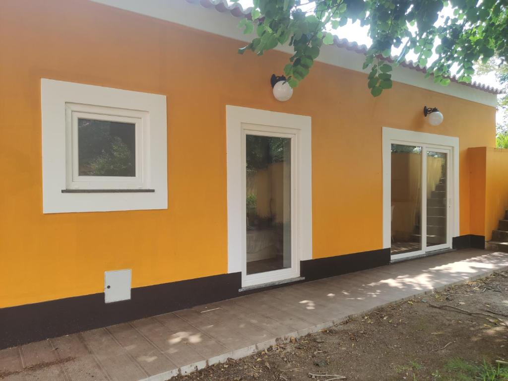 a house with orange walls and white windows at Quinta das Bicas AL in Angra do Heroísmo