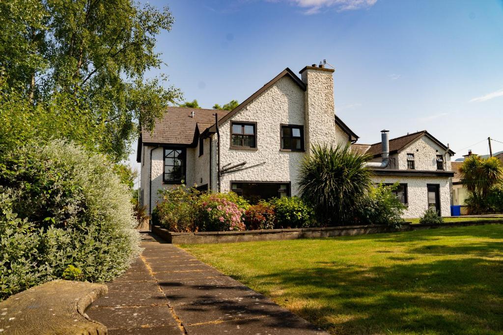 a large white house with a grass yard at The Briers Country House in Newcastle