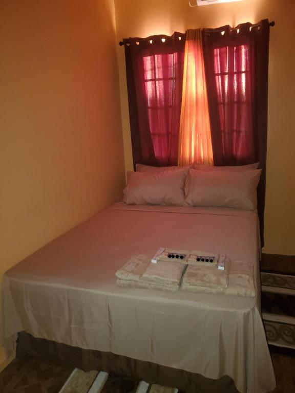 a bed in a room with a red window at K&L Private Room Suites in Arima