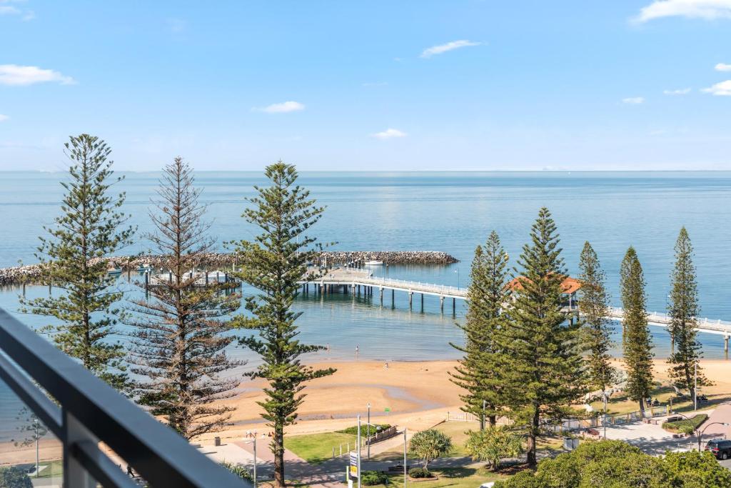 a view of a beach and the ocean from a balcony at Proximity Waterfront Apartments in Redcliffe