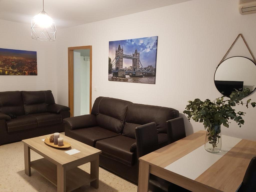 sala de estar con sofá y mesa en APARTAMENTo ENCANTADOR, en Lucena