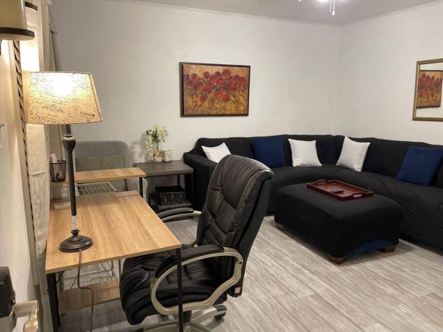 een woonkamer met een zwarte bank en een tafel bij Comfort & Quiet in a central location in Elizabeth City