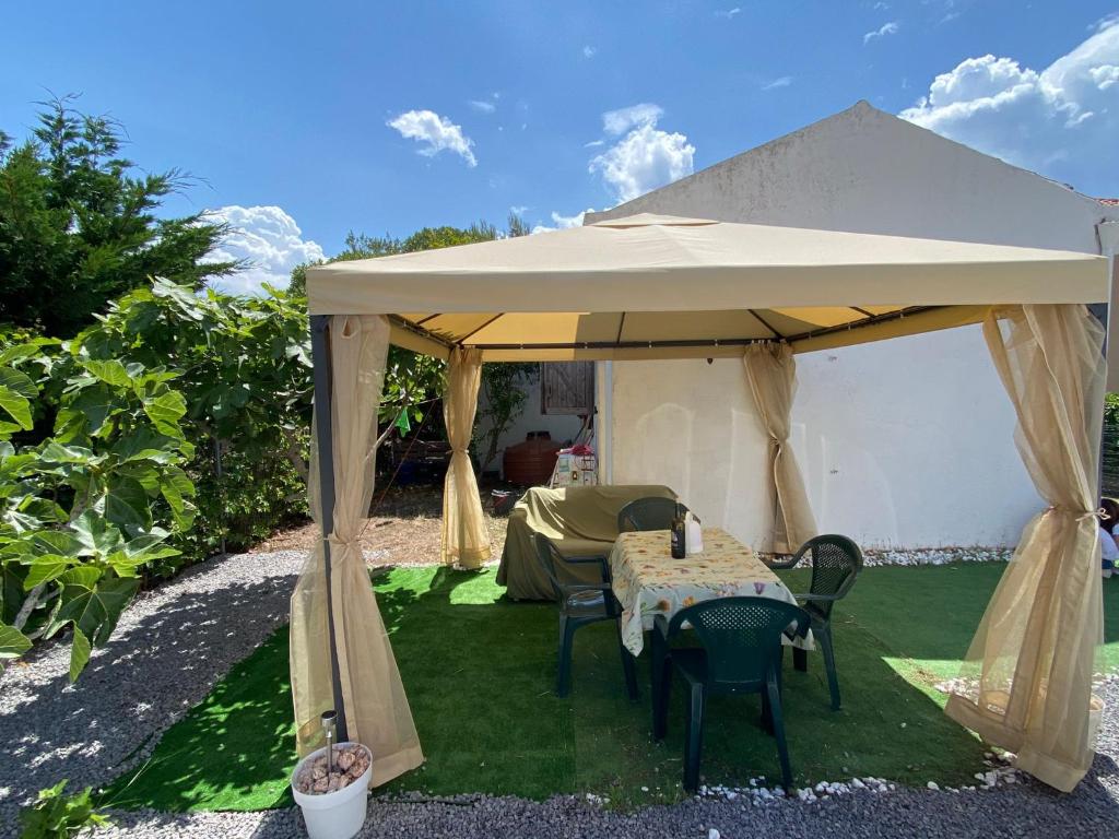 a tent with a table and chairs in a yard at Casa Frontemare in Carloforte