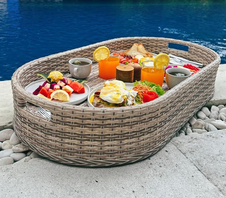 a basket filled with food and drinks next to the water at Villa Neshama in Canggu