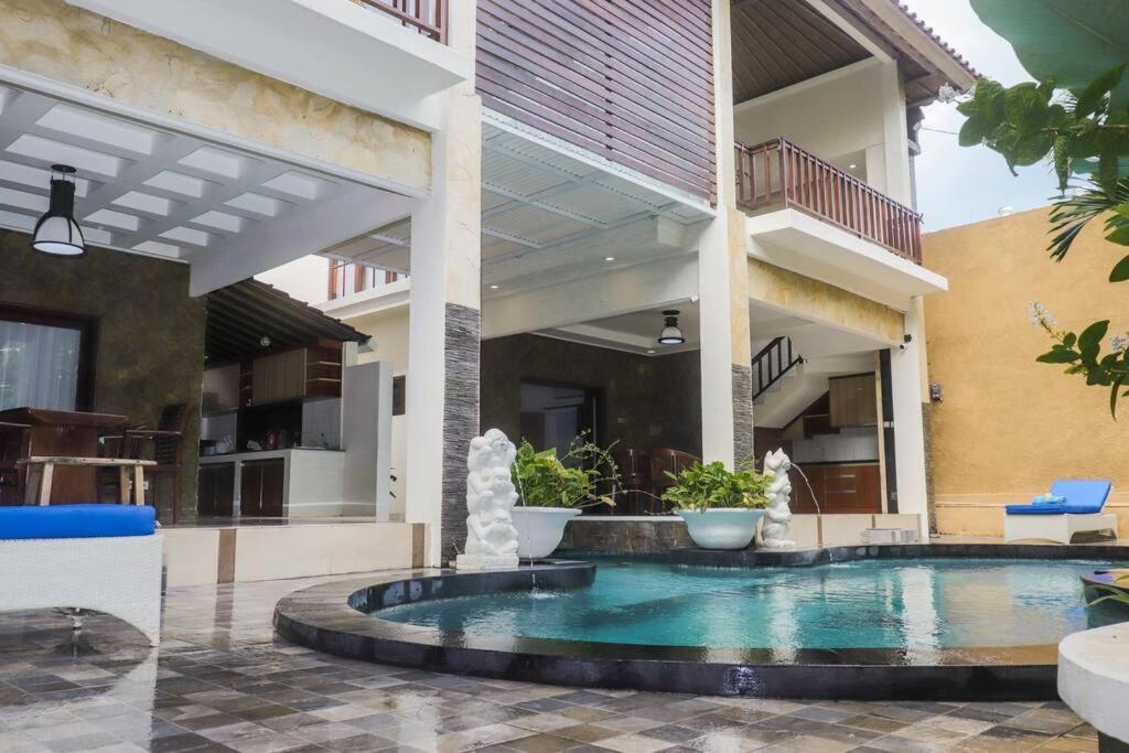 a swimming pool in the courtyard of a house at Dzawani Villa Kerobokan in Kerobokan