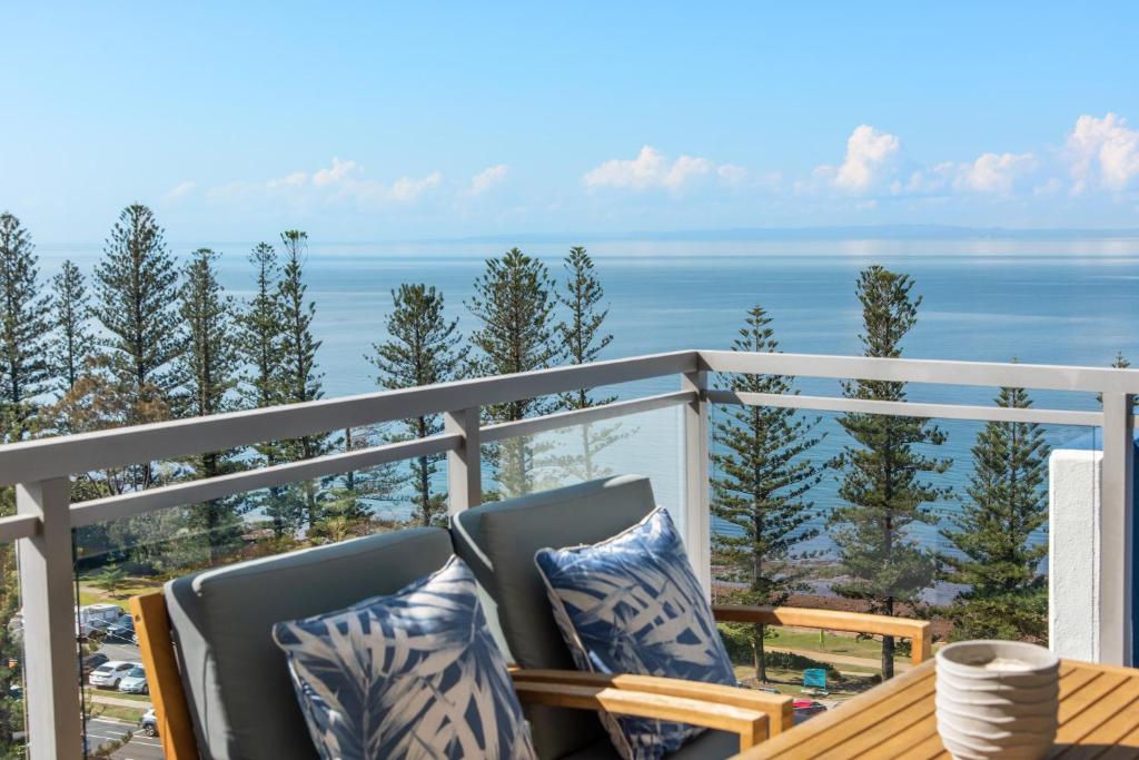 a balcony with chairs and a view of the ocean at Proximity Waterfront Apartments in Redcliffe
