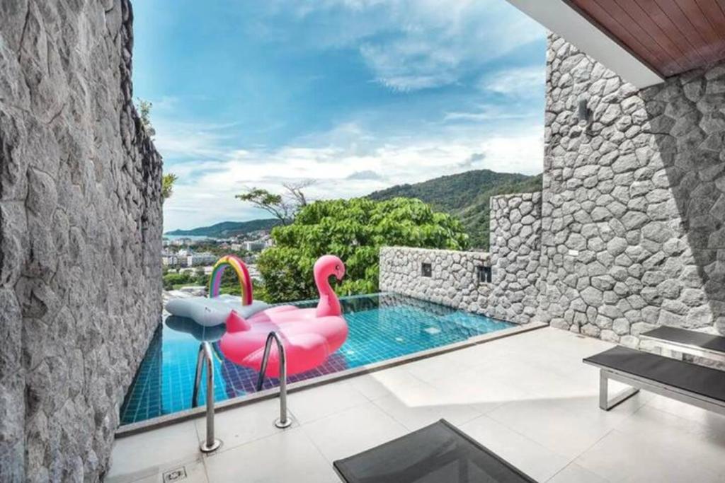 a swimming pool with a pink flamingo in a house at Patong Villa1：3卧泳池别墅【两个海景房】 近班赞江西冷海滩【中文管家】提供摩托车 in Patong Beach