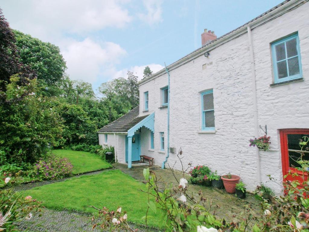 Henllan AmgoedにあるParke Cottageの青い扉と庭のある白い家
