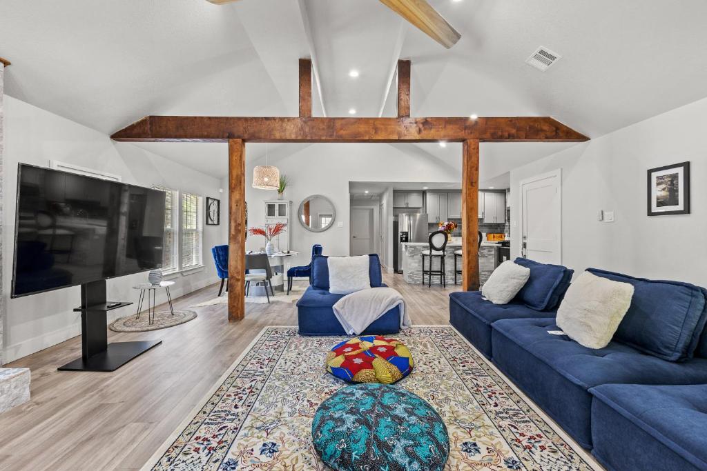 a living room with a blue couch and a tv at Joys Galleria Luxury Homes in Houston