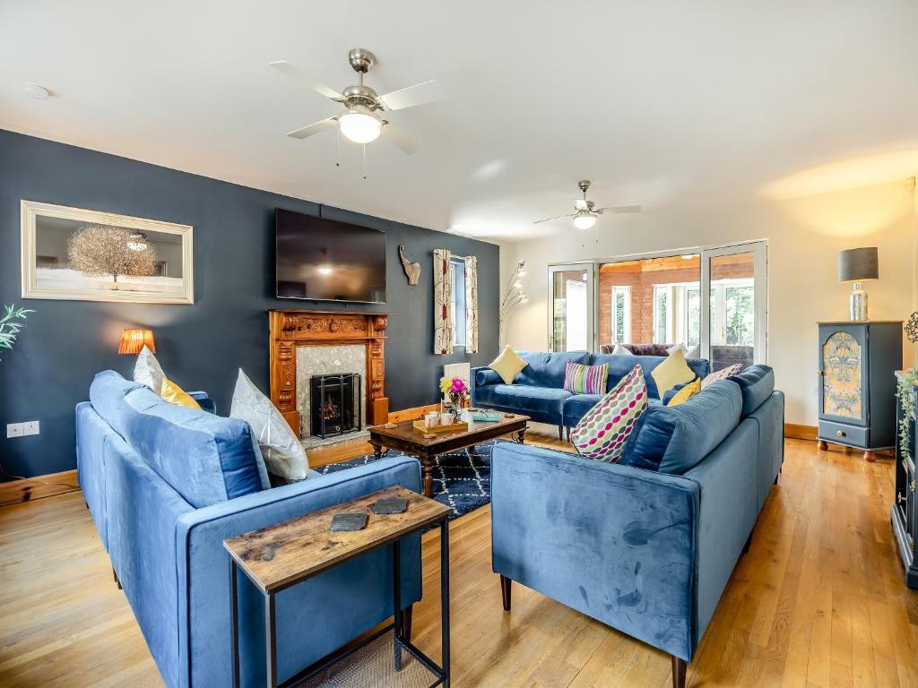 a living room with blue couches and a fireplace at Welton House in Orby