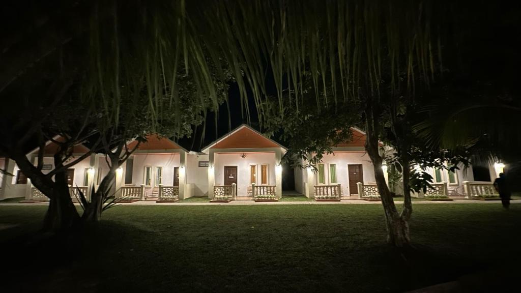 una casa de noche con árboles delante de ella en TC Garden Resort en Kuah