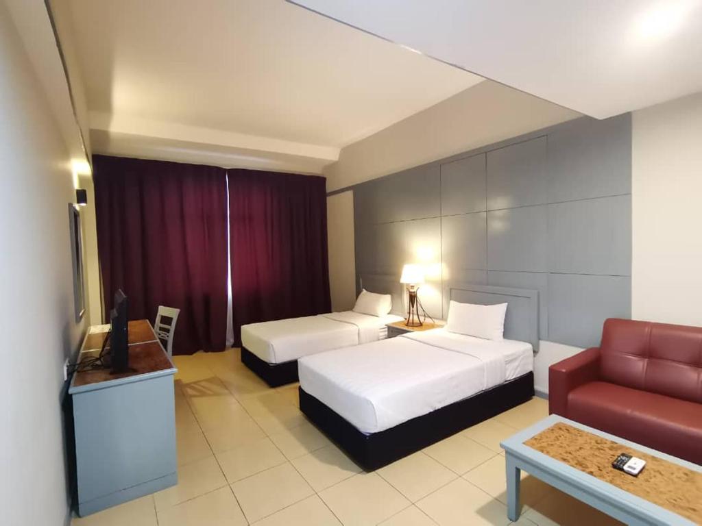 Postel nebo postele na pokoji v ubytování Grace Hotel Lahad Datu