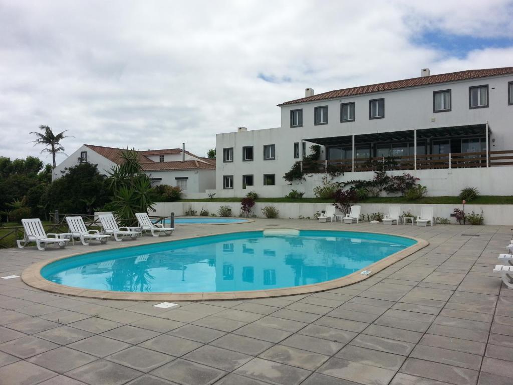 uma piscina em frente a um edifício em Apartamentos Turisticos Nossa Senhora Da Estrela em Rosário-Lagoa