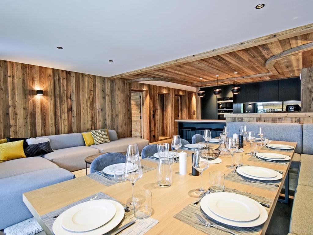 a dining room with a table and a couch at Appartement de Luxe avec SPA et Terrasse - 8 Couchages, Méribel - FR-1-613-44 in Méribel