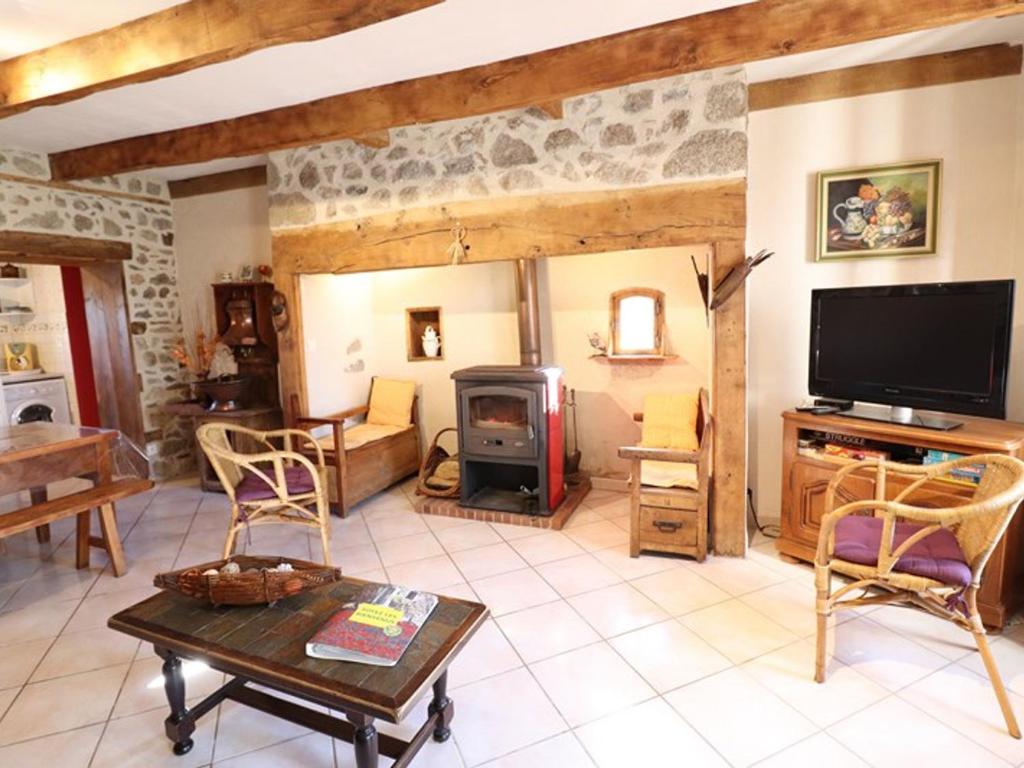 a living room with a tv and a fireplace at Gîte Sansac-Veinazès, 3 pièces, 4 personnes - FR-1-742-114 