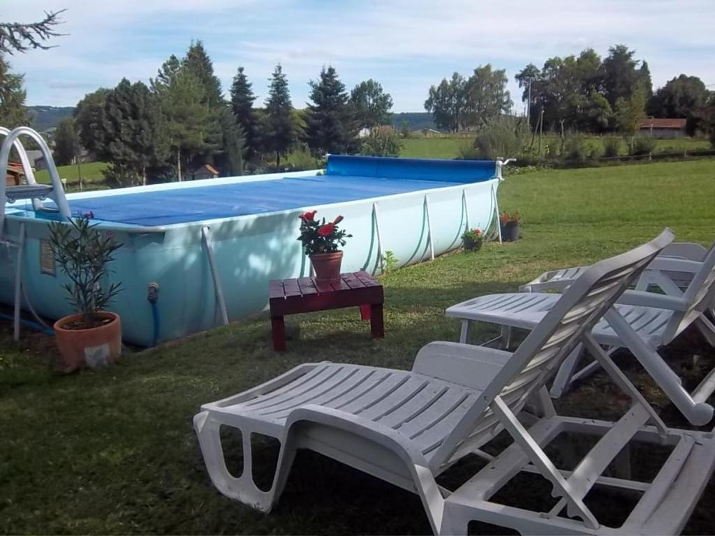 a pair of chairs and a table and a swimming pool at Gîte Sansac-Veinazès, 3 pièces, 4 personnes - FR-1-742-114 