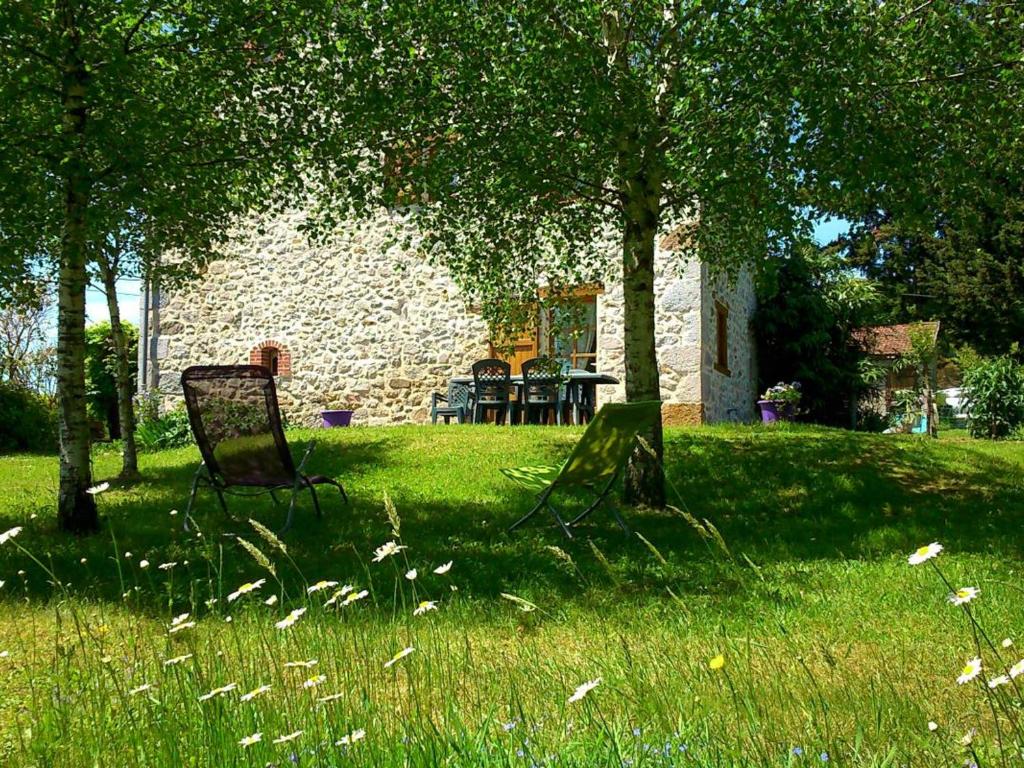 two chairs sitting in the grass under trees at Gîte Sansac-Veinazès, 3 pièces, 4 personnes - FR-1-742-114 