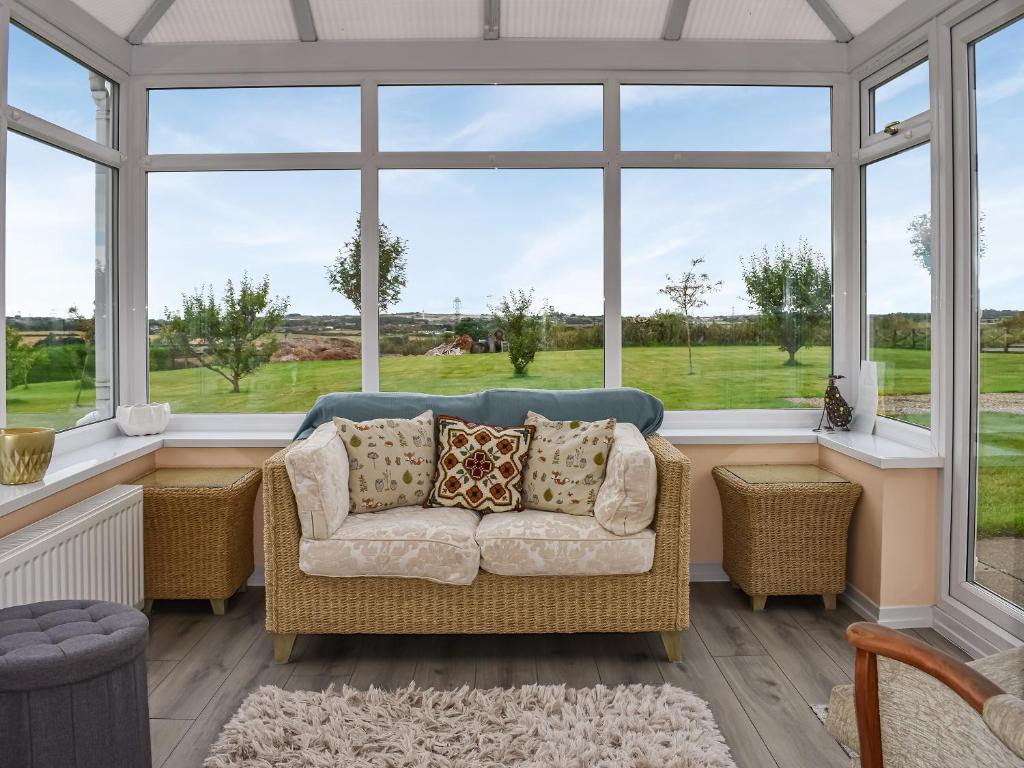 a living room with a couch and large windows at The Old Byre in Haswell