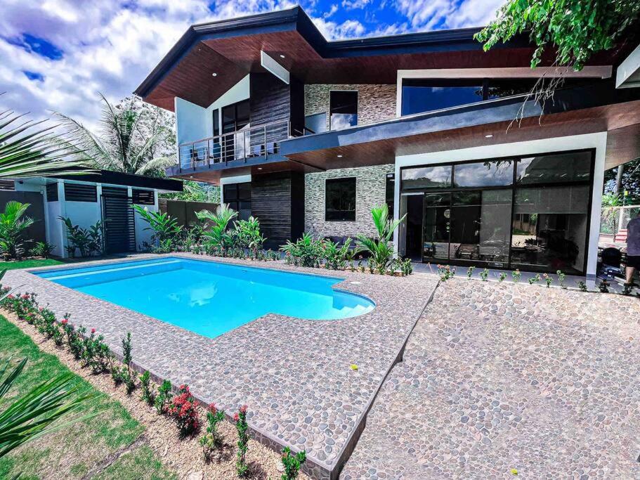 uma casa com uma piscina em frente em Hector House em Uvita