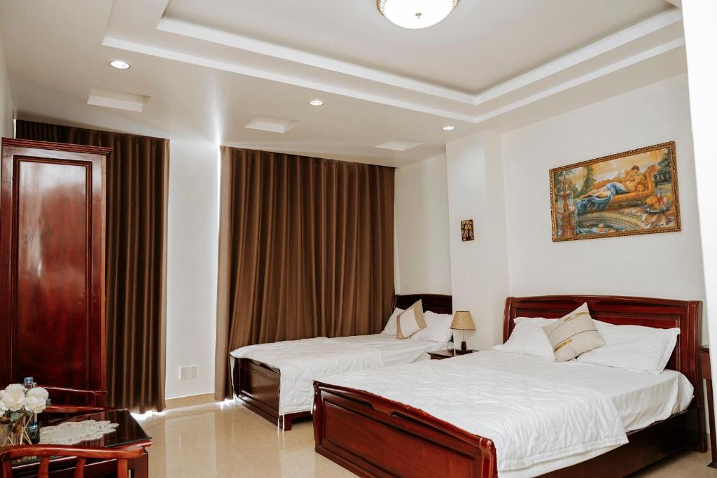Thao Vy Hotel في هاي فونج: غرفة نوم بسريرين ولوحة على الحائط