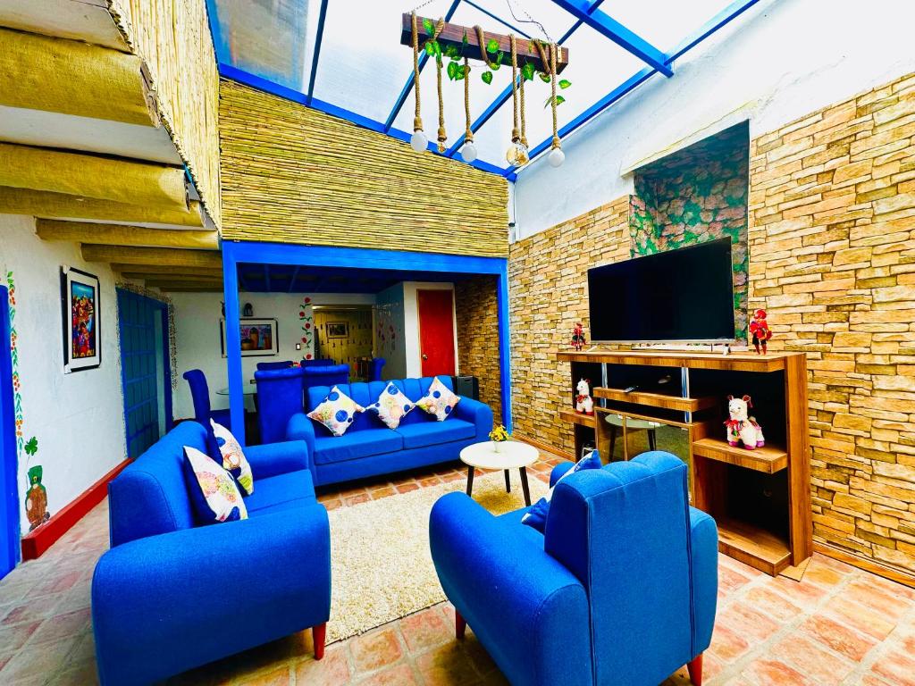 sala de estar con sofás azules y TV de pantalla plana en AITANA'S HOUSE - SAN BLAs, en Cusco
