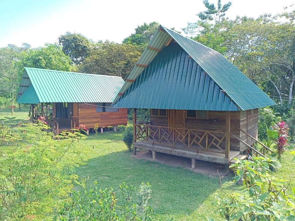 Cabaña de madera pequeña con techo azul en Quirquincho House en Puerto Maldonado