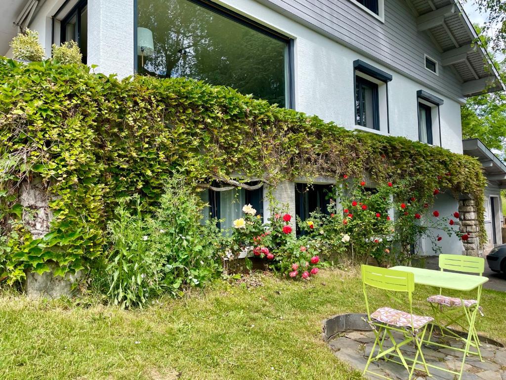 a green table and chairs in front of a house at Appartement indépendant 30 m² à 500m du lac, 2 vélos et parking fournis in Sévrier