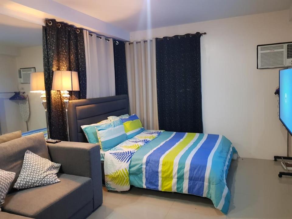 a bedroom with a bed and a couch at Affordable place to stay near cebu city in Cebu City
