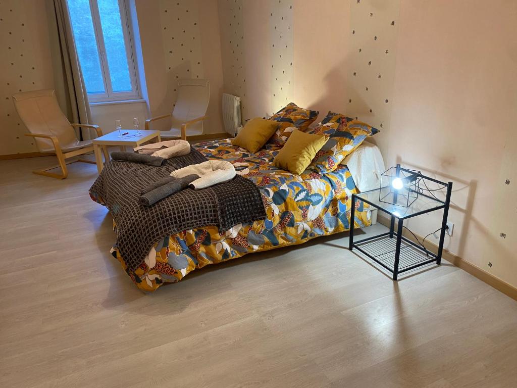 Una cama con edredón y una mesa en una habitación en Chez Precillia et Fabrice, en Montlaur