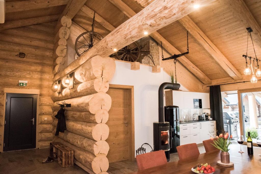 a living room with a wooden wall and a kitchen at Blockhausen in Schwarzenberg am Bohmerwald