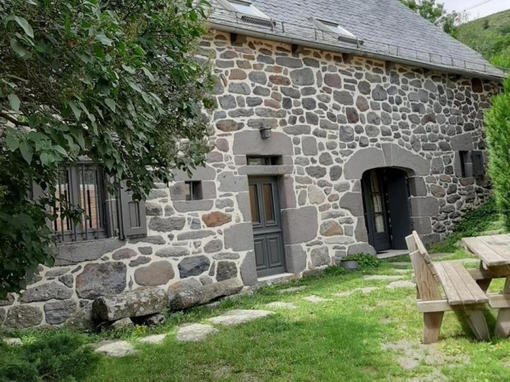 a stone building with a bench in front of it at Gîte Paulhac, 6 pièces, 12 personnes - FR-1-742-420 in Paulhac