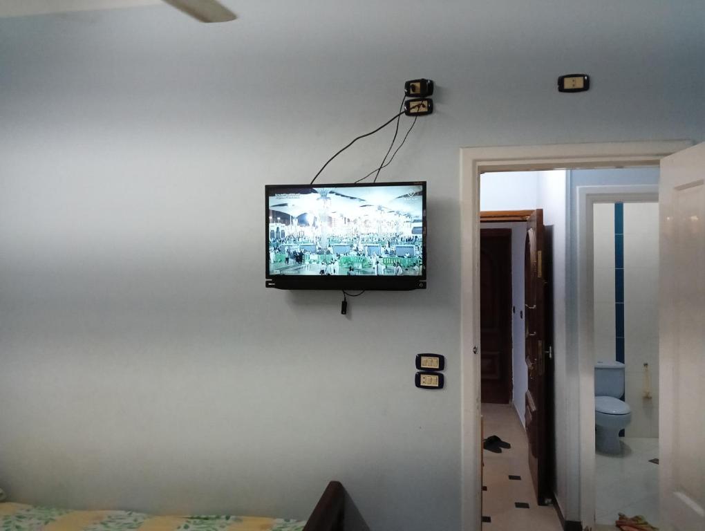 einen Flachbild-TV an der Wand eines Schlafzimmers in der Unterkunft شارع ٨٩ فيلا ٢٤ in ‘Izbat al Burj