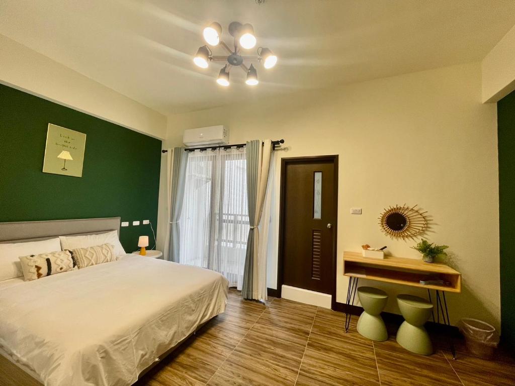 ein Schlafzimmer mit einem weißen Bett und einer grünen Wand in der Unterkunft Mian Bao Homestay in Magong