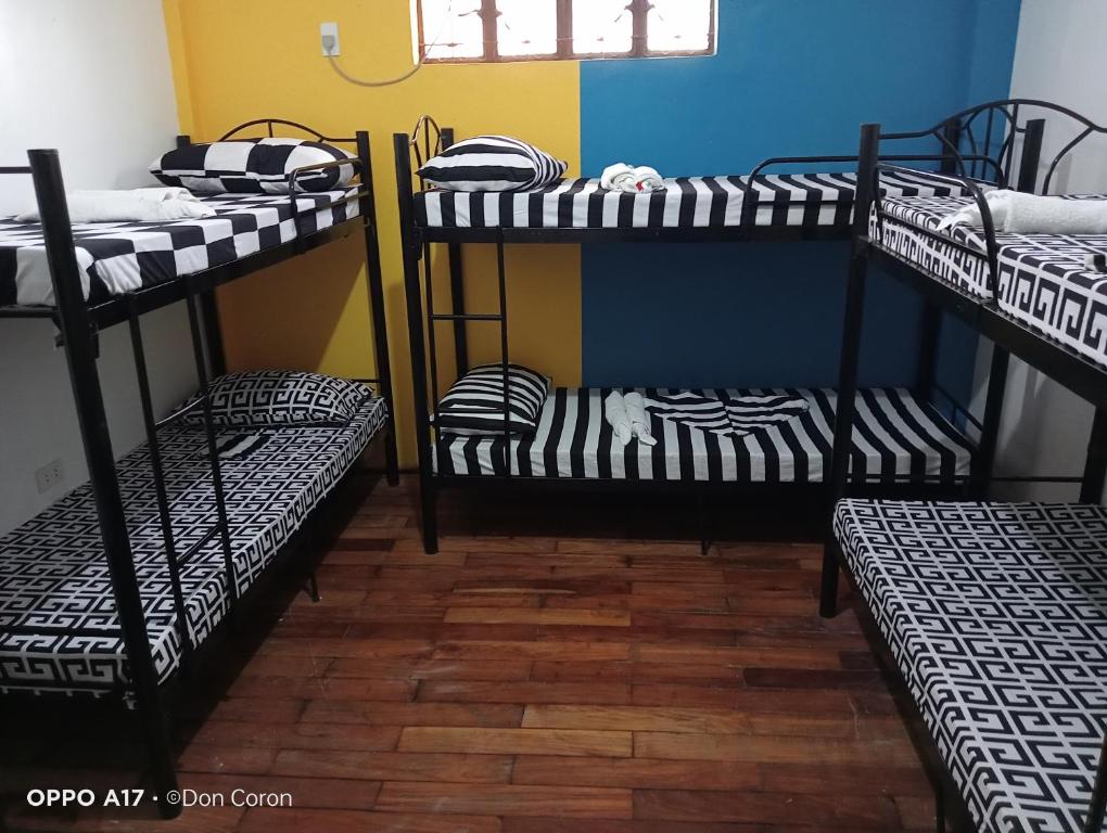 a room with three bunk beds in it at Footprints Hostel in Coron