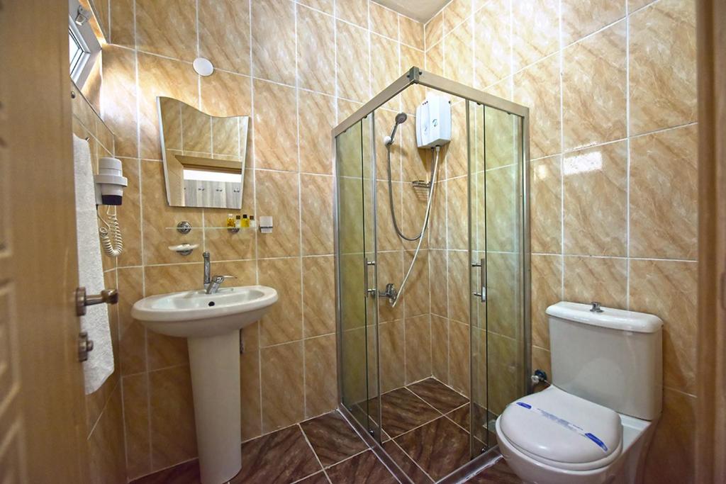 a bathroom with a shower with a toilet and a sink at Inebolu Gardenya Hotel in Inebolu