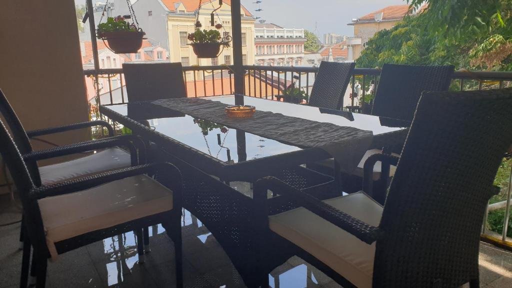 una mesa negra y sillas en el balcón en Roman Stadium Apartments, en Plovdiv