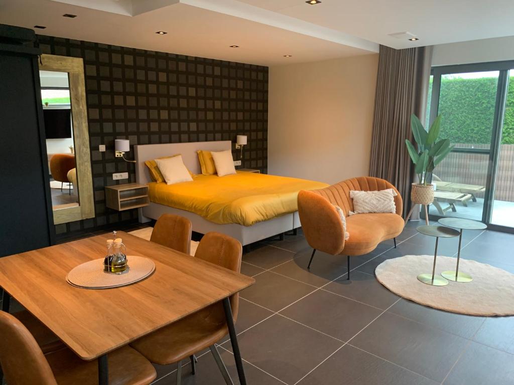 una camera con letto, tavolo e sedie di Q Guesthouse a Herzele