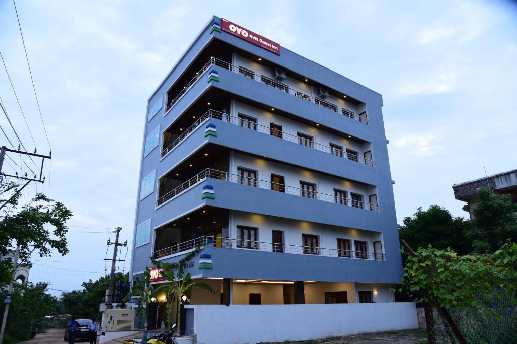 un edificio alto azul con un letrero. en Hotel RVN, en Nellore